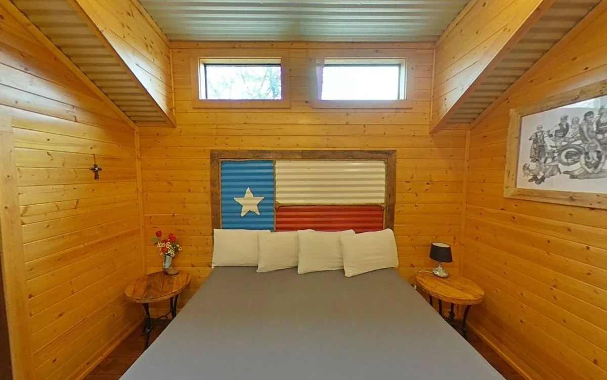 Cabin #1 at Al's Hideaway — cozy king bed retreat with Texas flag headboard
