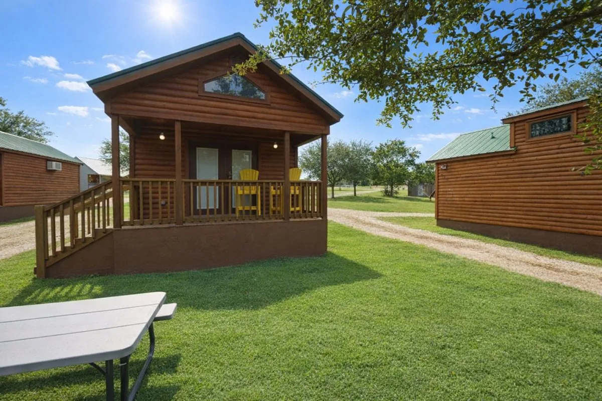 Cabin #3 at Al's Hideaway — log cabin exterior with yellow porch chairs