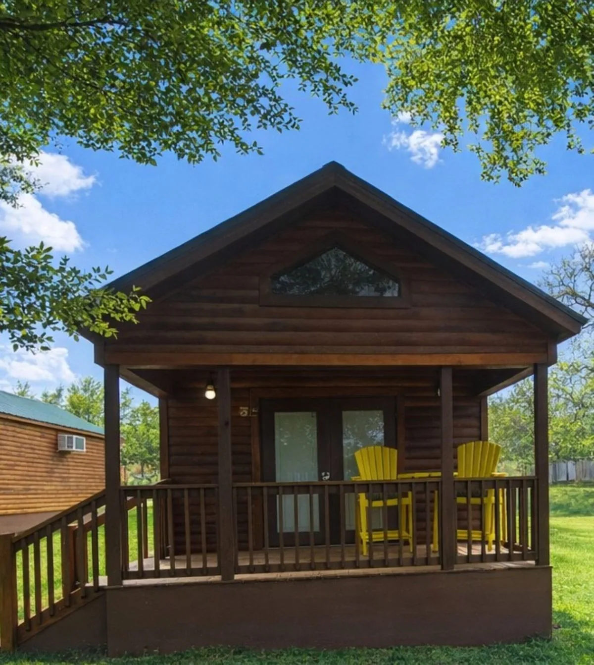 Cabin #5 at Al's Hideaway — log cabin with covered porch and yellow chairs
