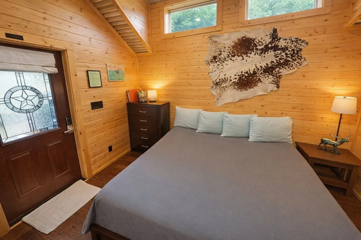 Cabin #8 at Al's Hideaway — bedroom with cowhide wall decor and Texas star door